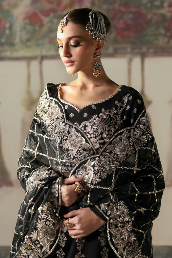 Husnara – Black raw silk lehenga choli with golden panni, tilla embroidery, sequins, and sheer embroidered dupatta.